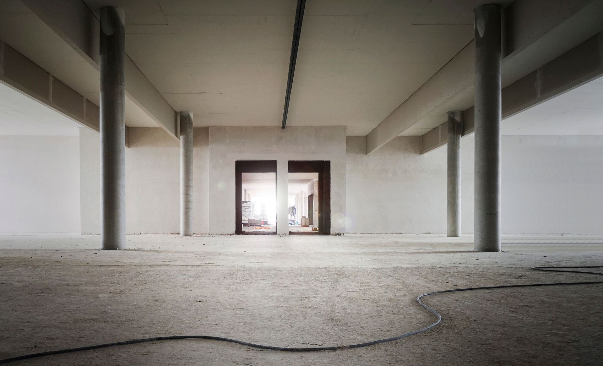 Industrial interior space with concrete columns and unfinished walls, perfect for renovation projects.