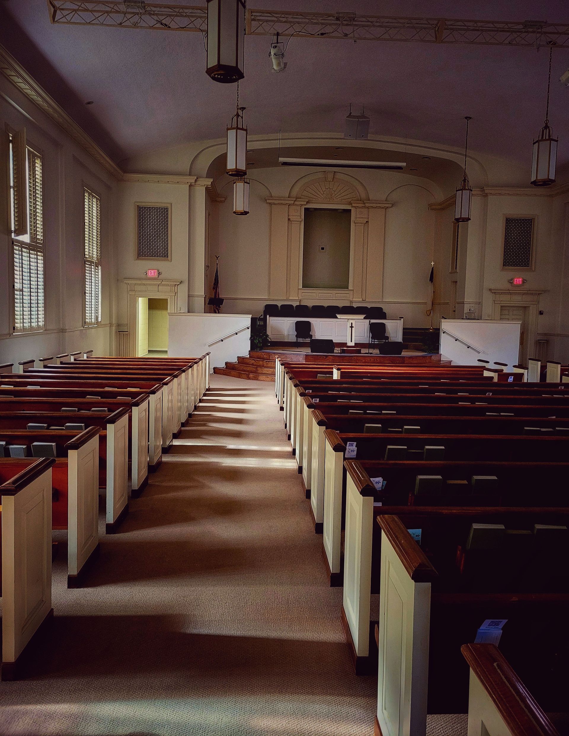 A serene and empty church interior with pews and pulpit, showcasing architectural beauty.